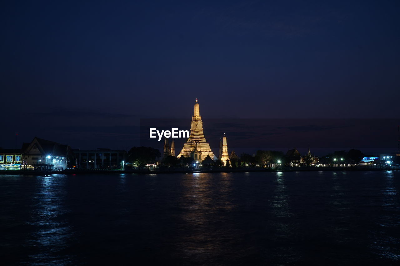 VIEW OF ILLUMINATED BUILDINGS AT WATERFRONT