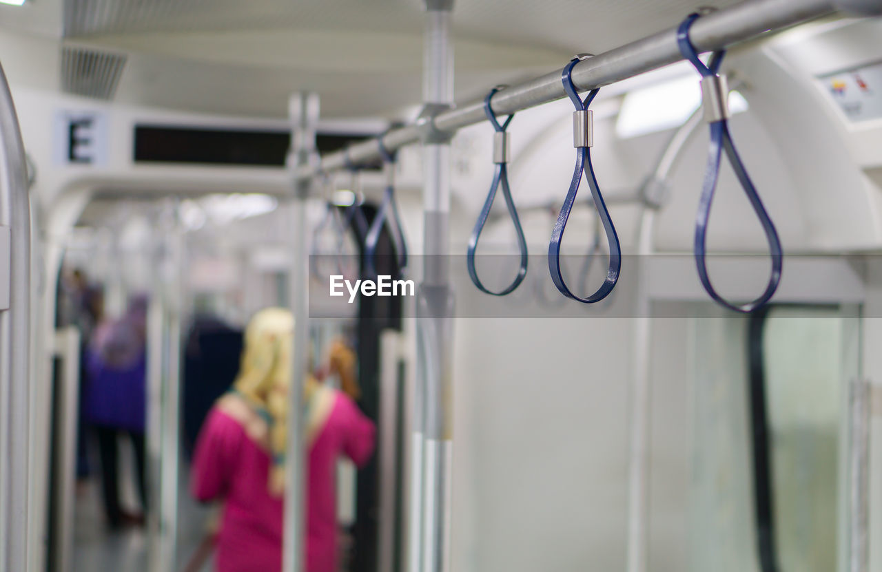 Close-up of handles on rack in metro train