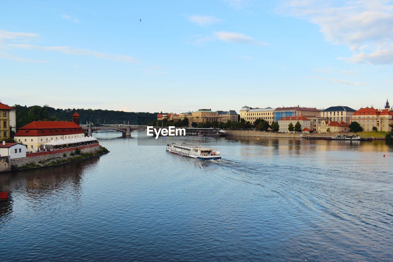 River by buildings in city against sky