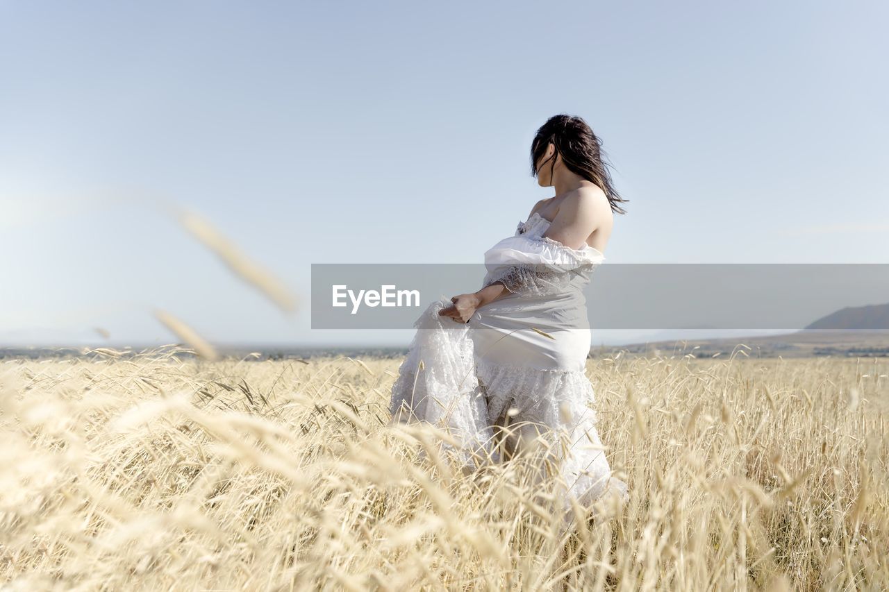side view of young woman standing on field