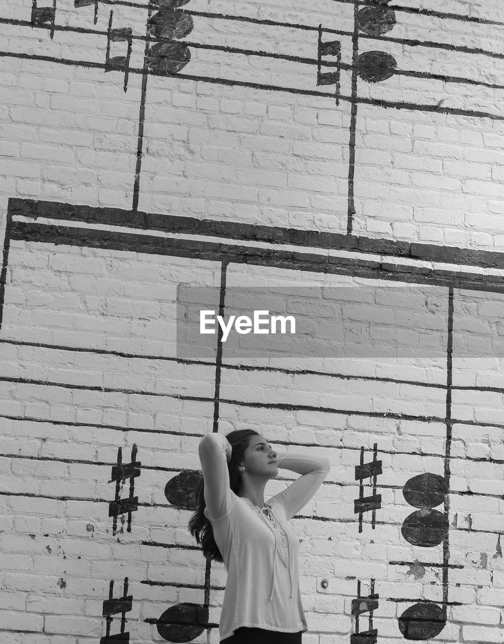 Young woman posing against wall