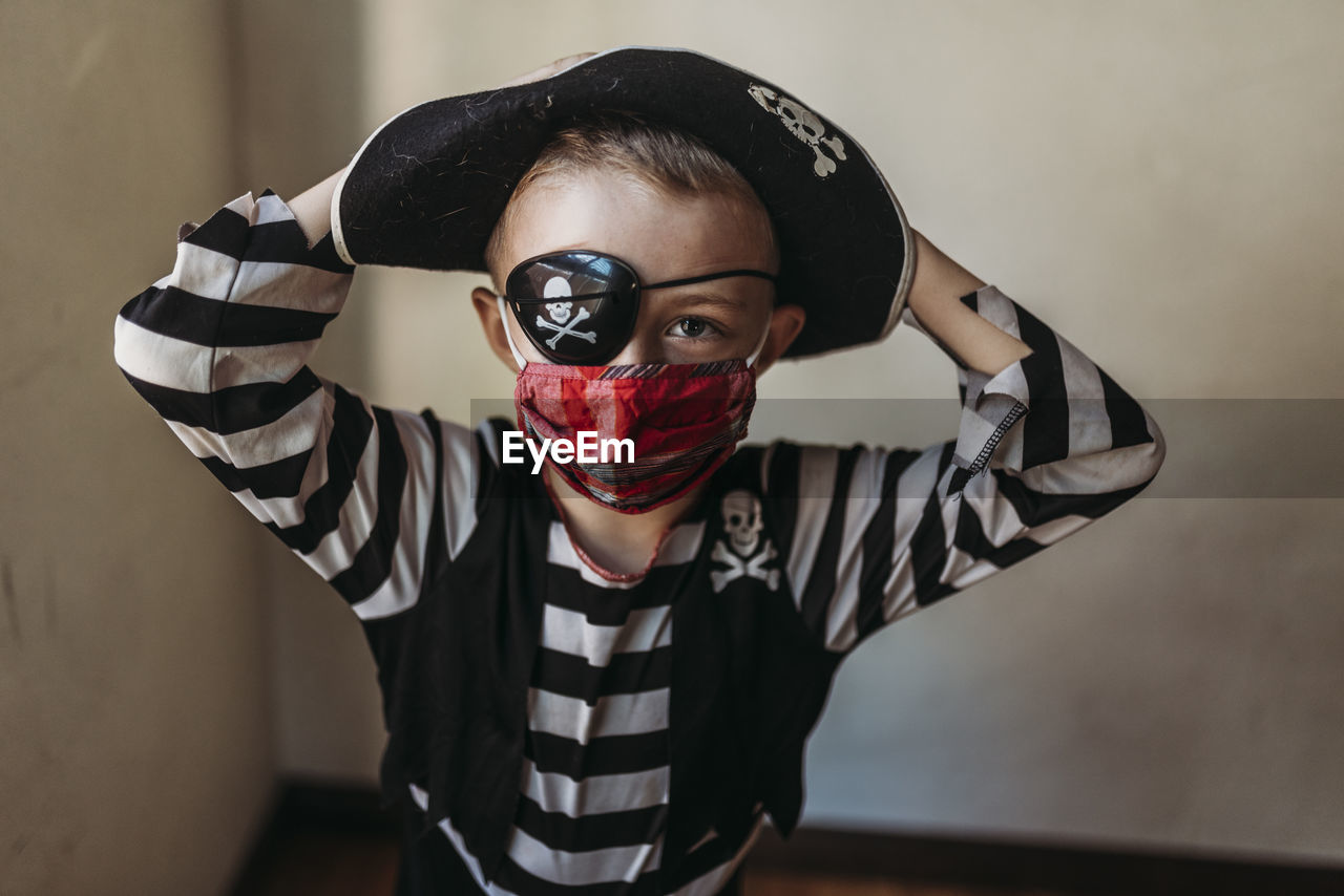 Portrait of school age young boy dressed as pirate with face mask on