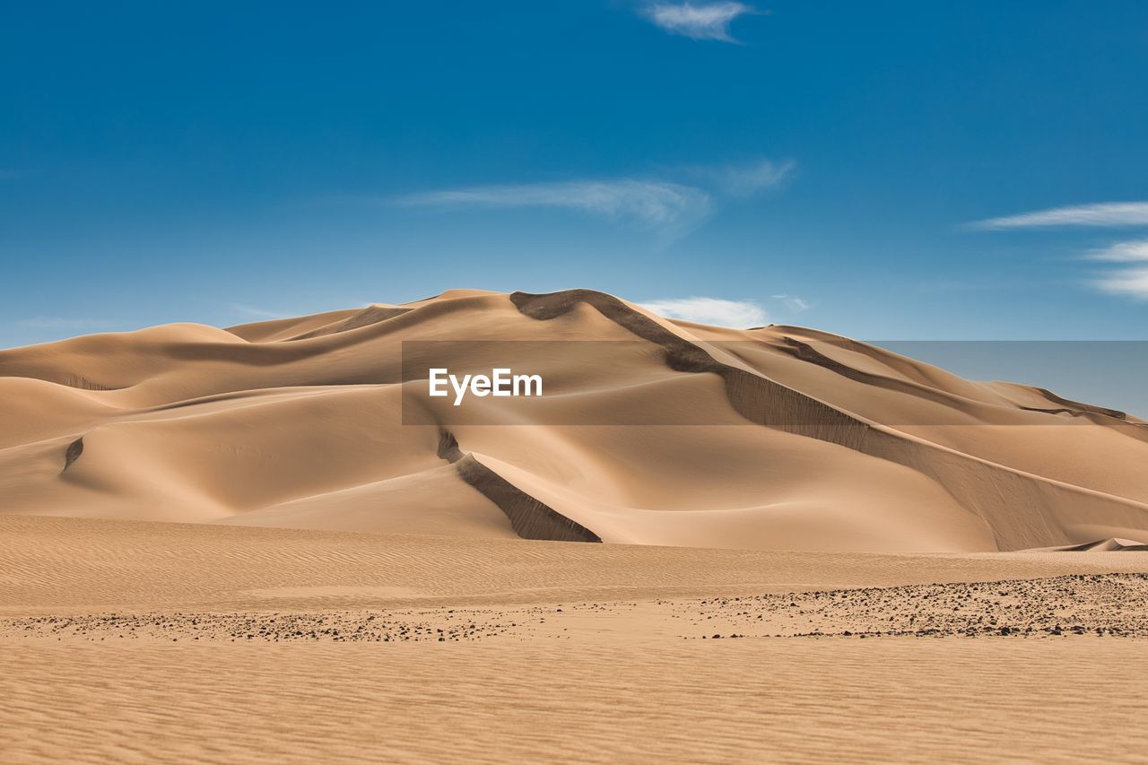 Sand dunes in desert against sky