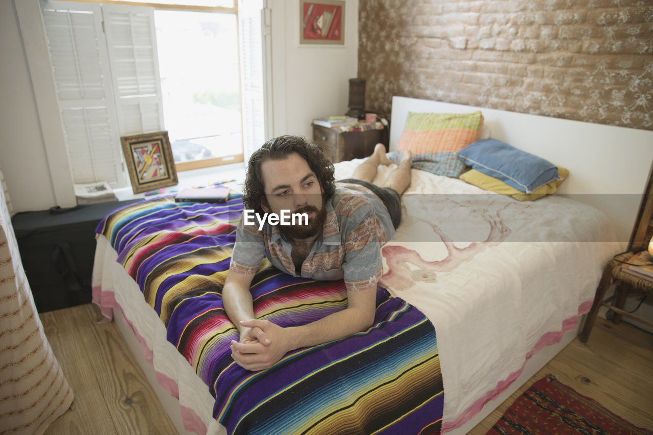 Young man lying on his bed