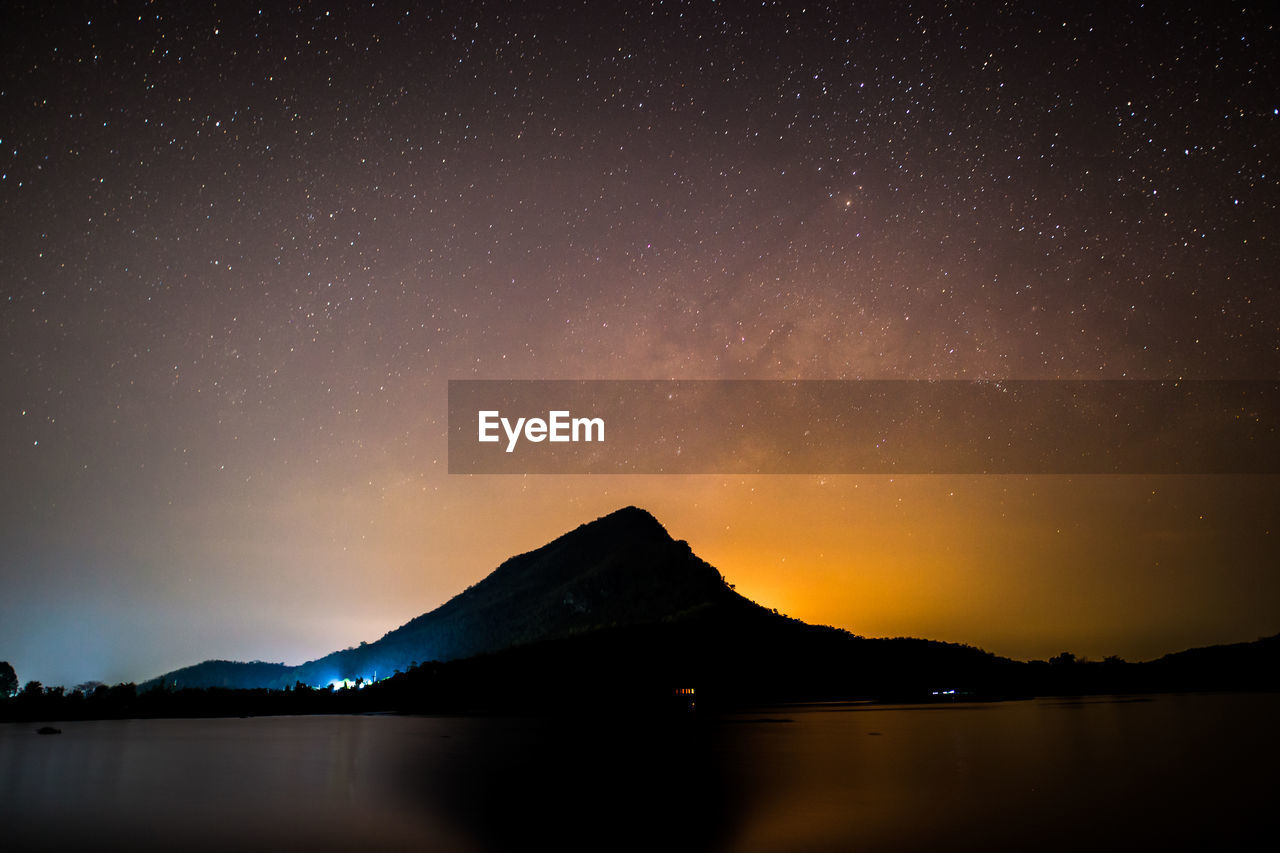 Scenic view of lake against sky at night