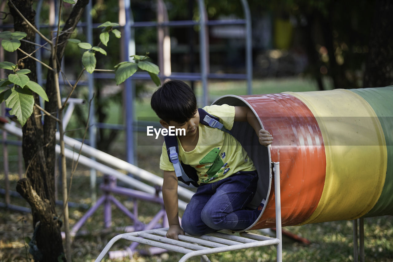 Boy playing on outdoor play equipment in playground