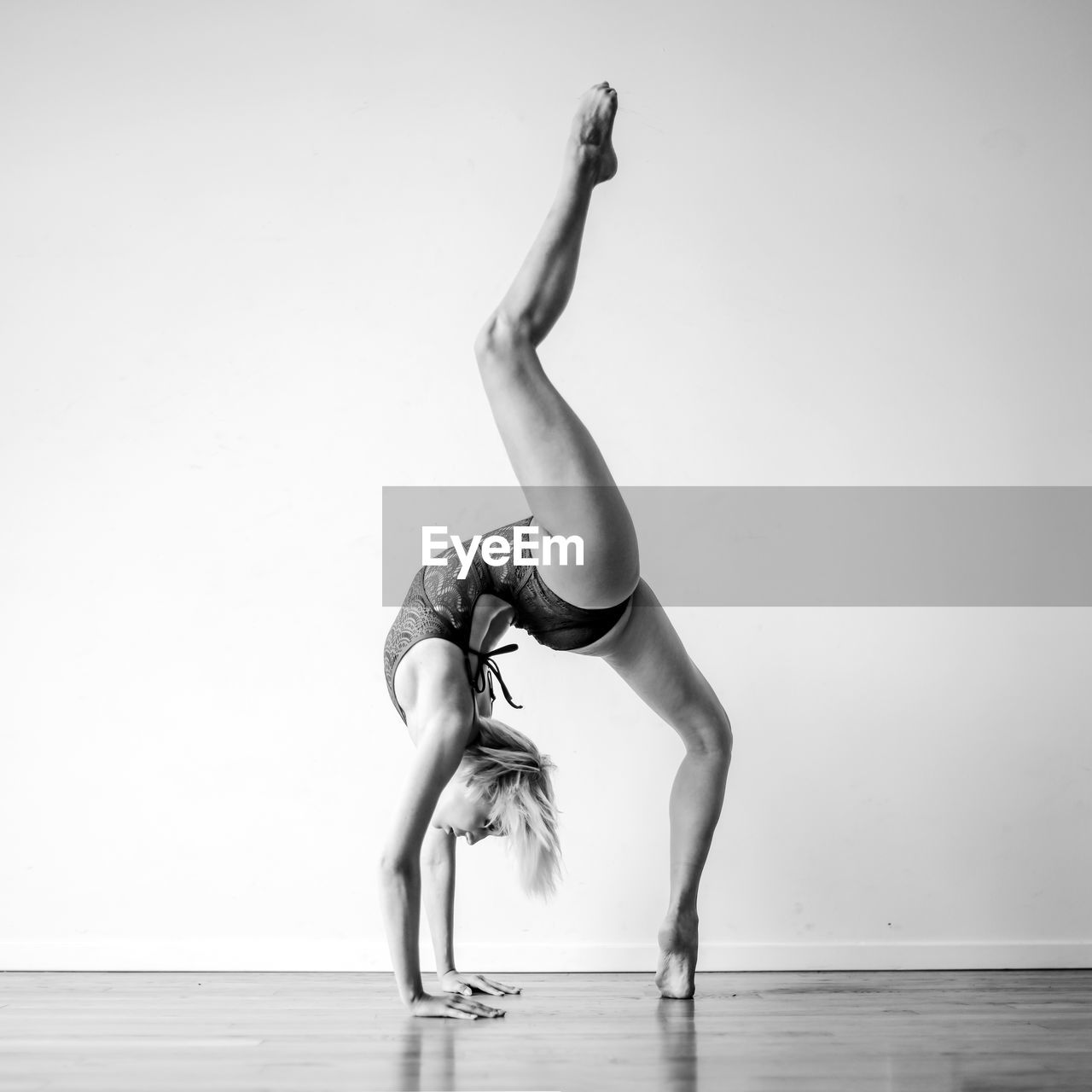 Full length of woman dancing on floor against white wall