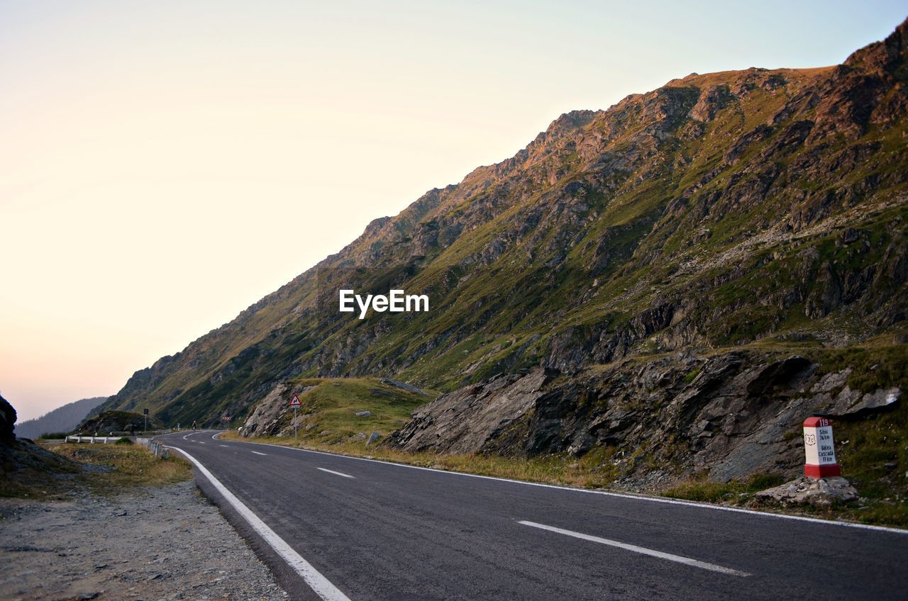 EMPTY ROAD BY MOUNTAIN AGAINST SKY