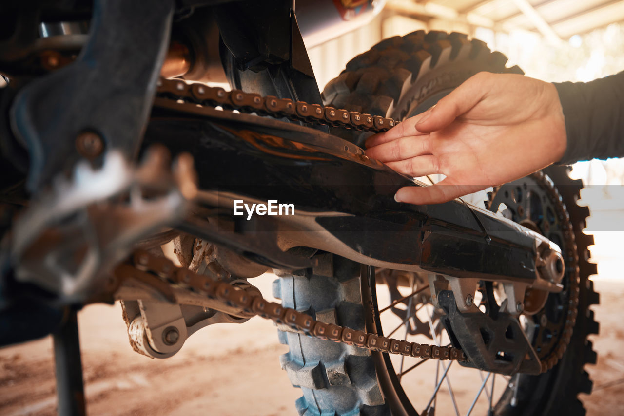 cropped hand of man repairing motorcycle