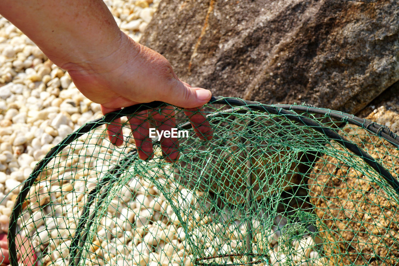 Close-up of hand holding fishing net