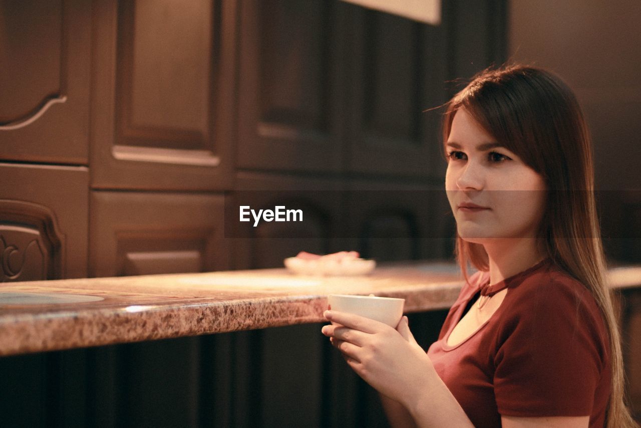 Young woman drinking coffee in cup