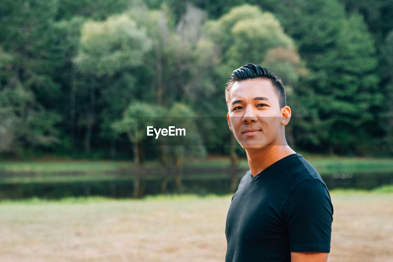 Portrait of man standing against trees outdoors