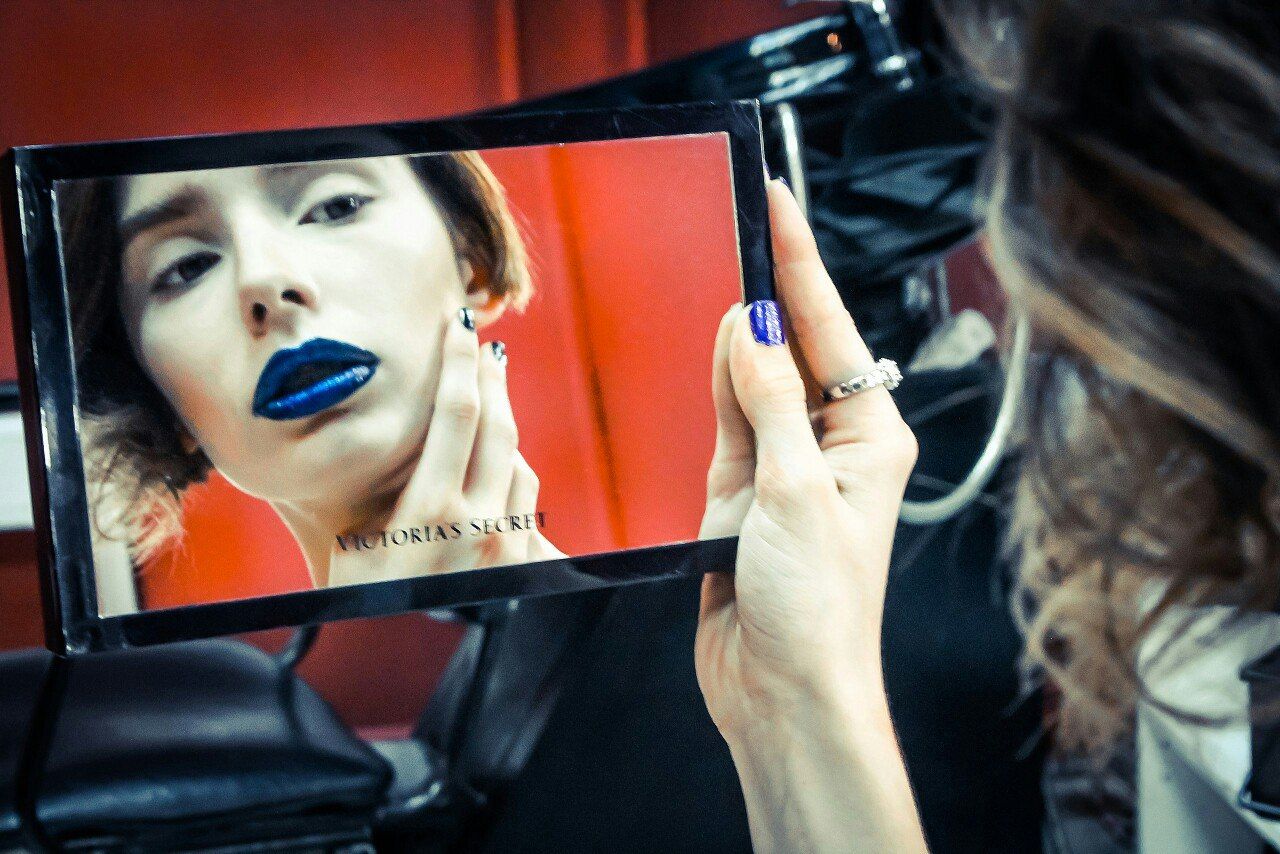 CLOSE-UP OF YOUNG WOMAN USING MOBILE PHONE IN KITCHEN