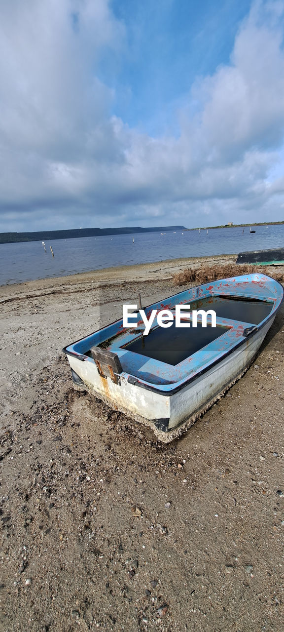 water, beach, land, sea, sky, shore, sand, cloud, nature, nautical vessel, boat, tranquility, scenics - nature, ocean, no people, transportation, coast, day, beauty in nature, tranquil scene, moored, vehicle, blue, travel, outdoors, mode of transportation, absence, horizon, horizon over water, travel destinations, vacation, trip, holiday, wave, bay, coastline, environment, watercraft, relaxation, non-urban scene