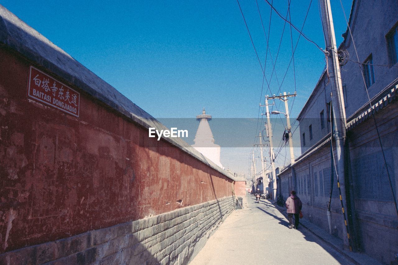 View of miaoying temple behind wall against sky