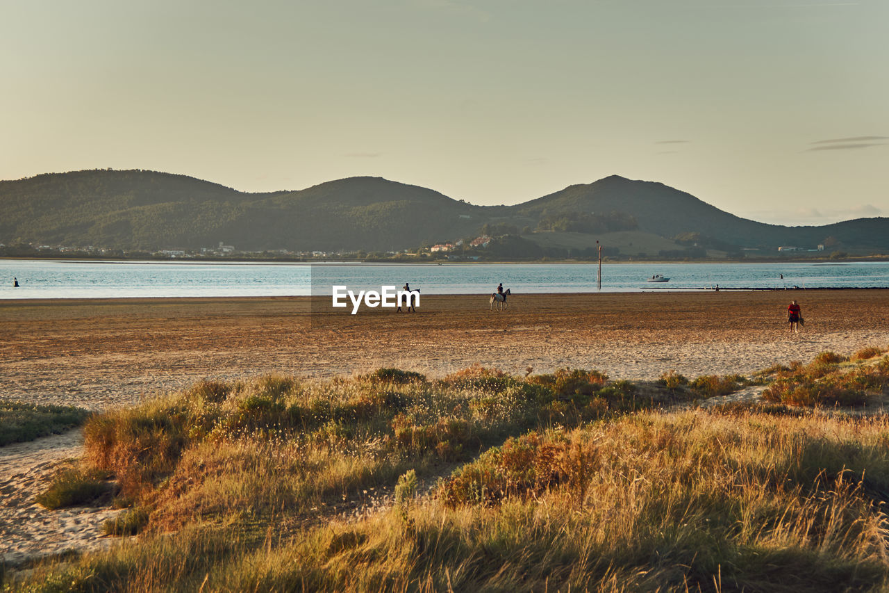 SCENIC VIEW OF BEACH AND MOUNTAINS AGAINST SKY