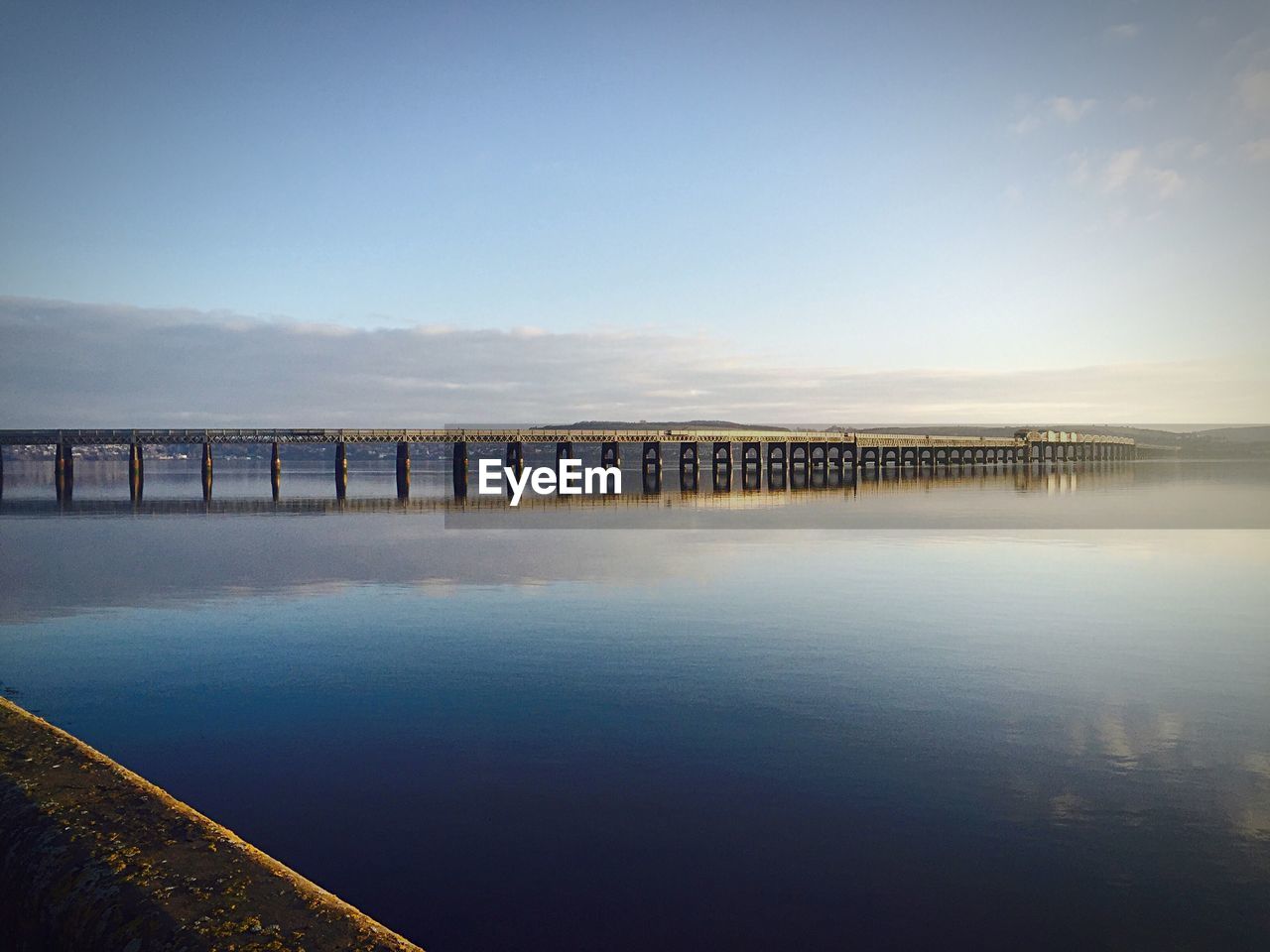 Bridge over sea against blue sky