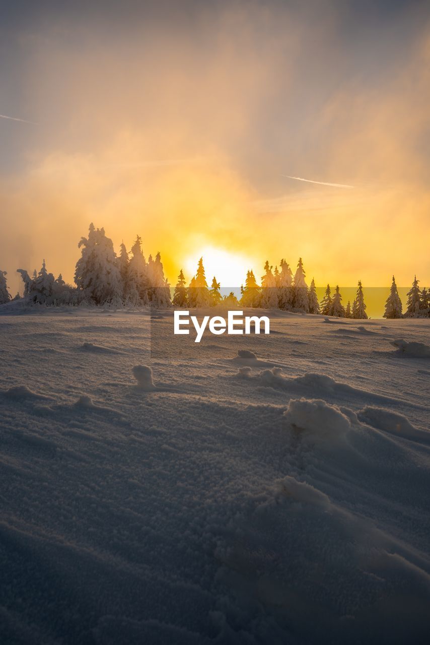 Idyllic shot of snow covered field against sky during sunset