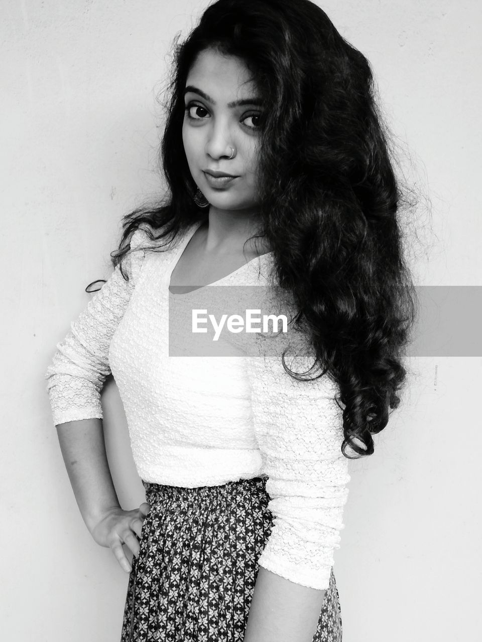 Smiling young woman standing against wall