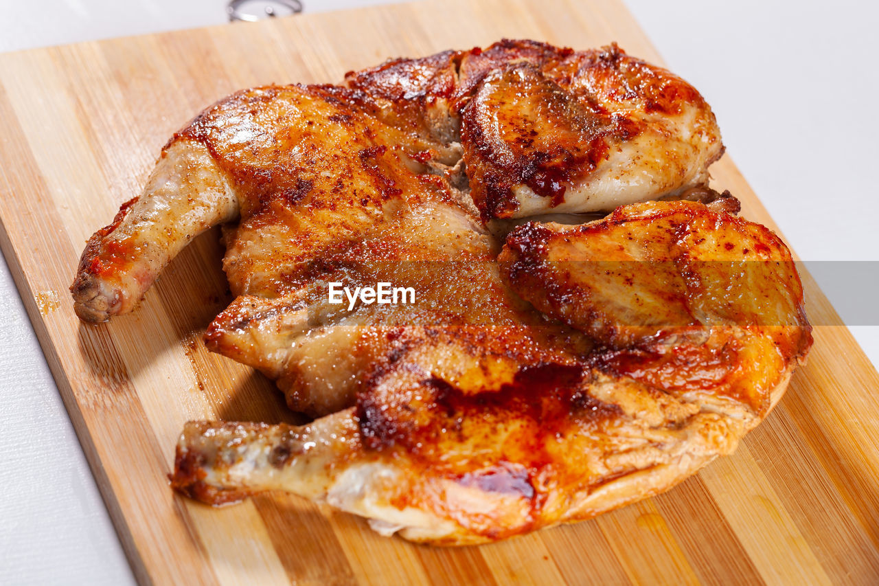 food and drink, food, dish, freshness, cuisine, indoors, meat, high angle view, table, no people, wood, still life, cutting board, fried food, close-up, fast food, wellbeing, healthy eating, produce, chicken meat, roasted, meal, chicken