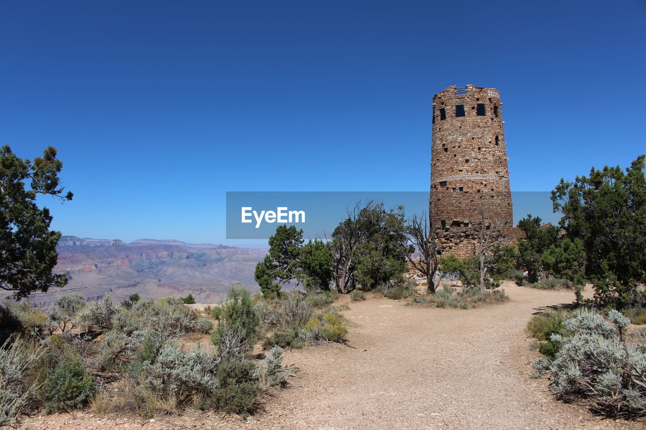 Built structure on landscape against blue sky