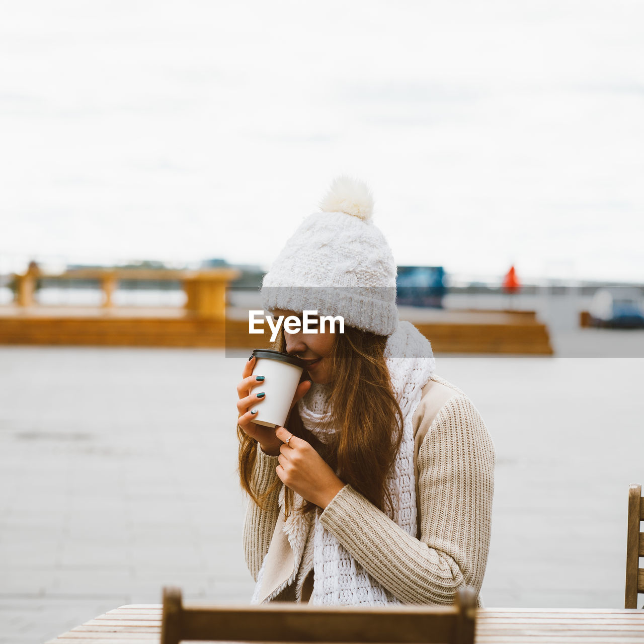 Young woman drinking coffee while sitting at outdoor cafe