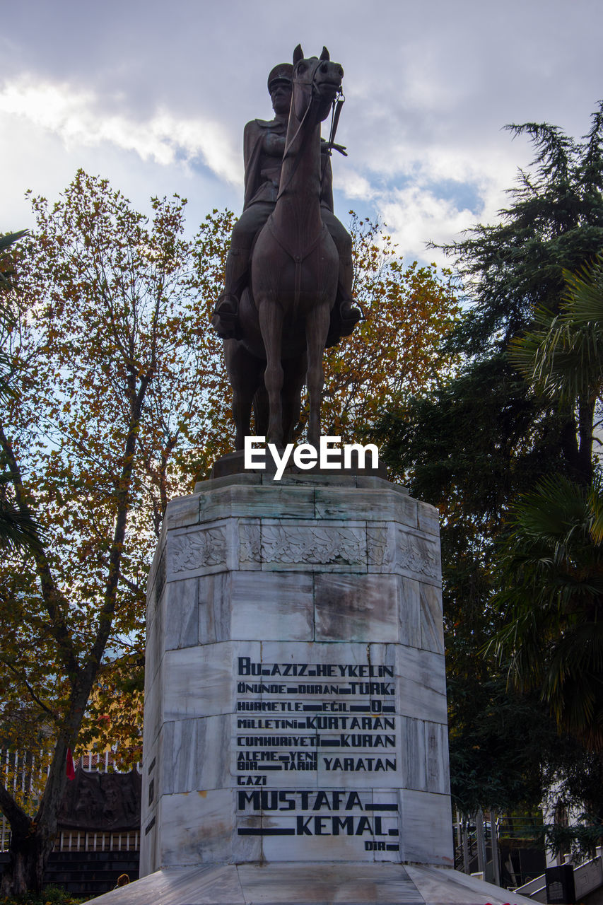 LOW ANGLE VIEW OF STATUE AGAINST TREE