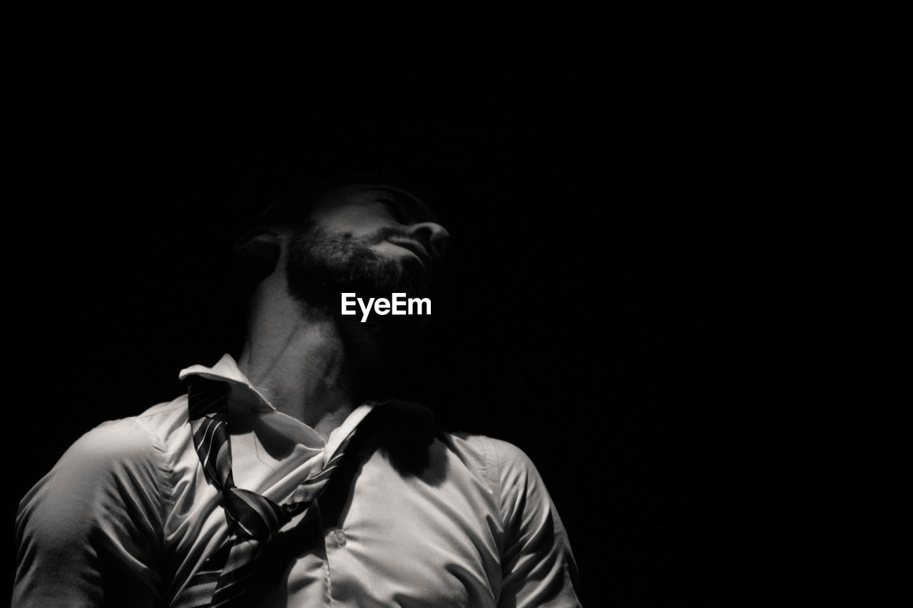 Midsection of man standing against black background