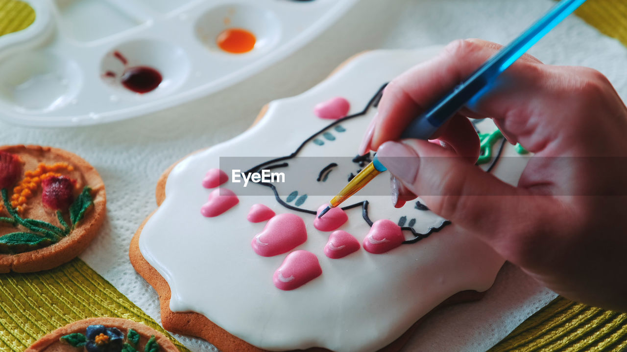 cropped hand of person painting on table