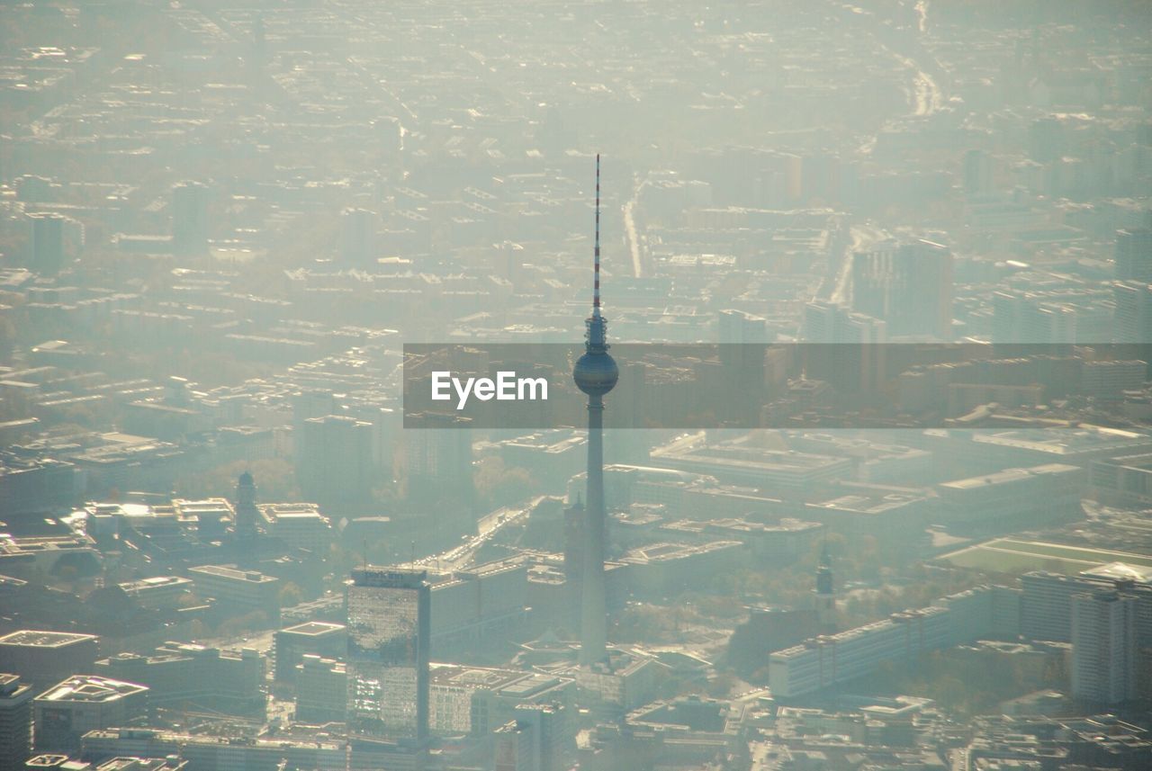 Aerial view of fernsehturm in city during foggy weather