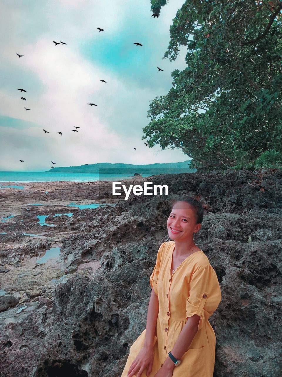 Woman standing at beach against sky