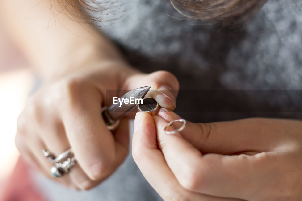 Midsection of woman inserting wood in ring