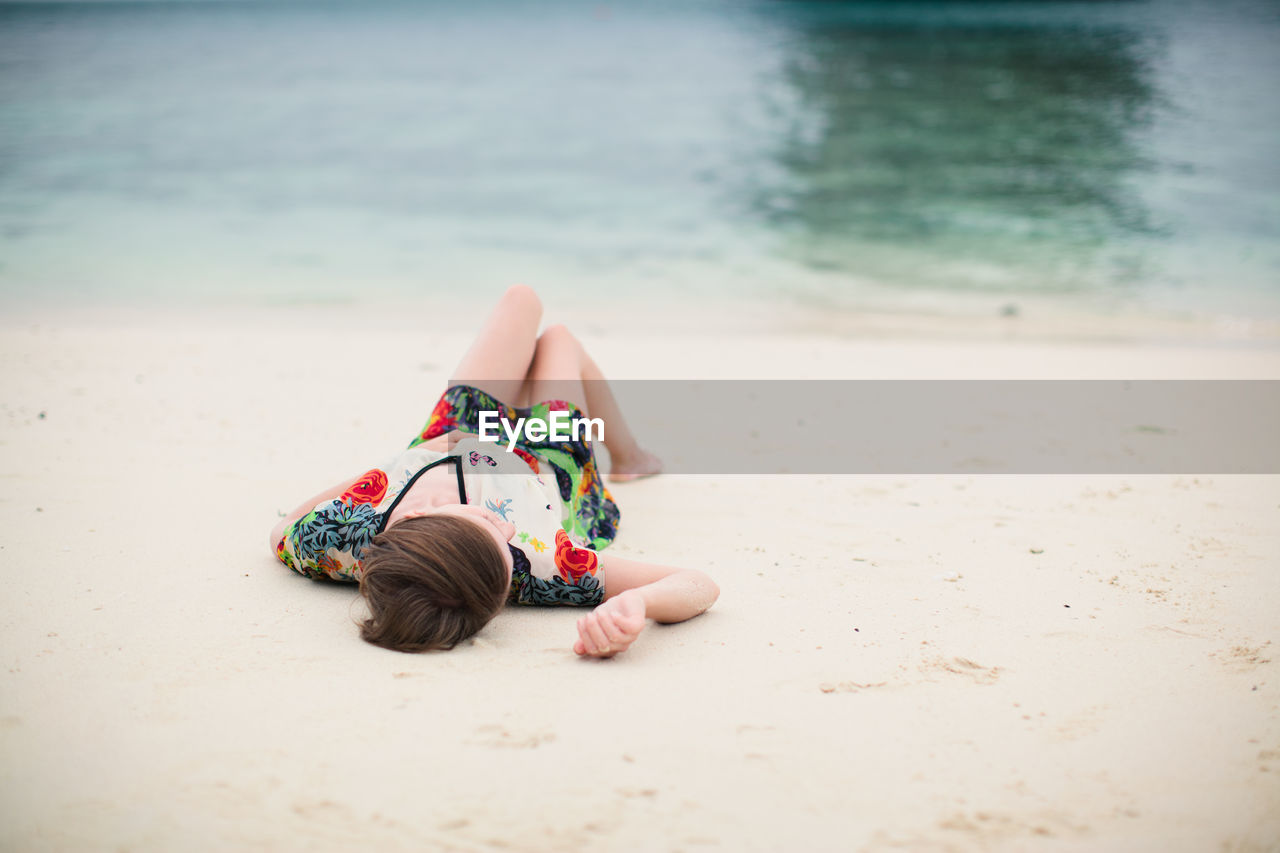 Young woman lying on sand
