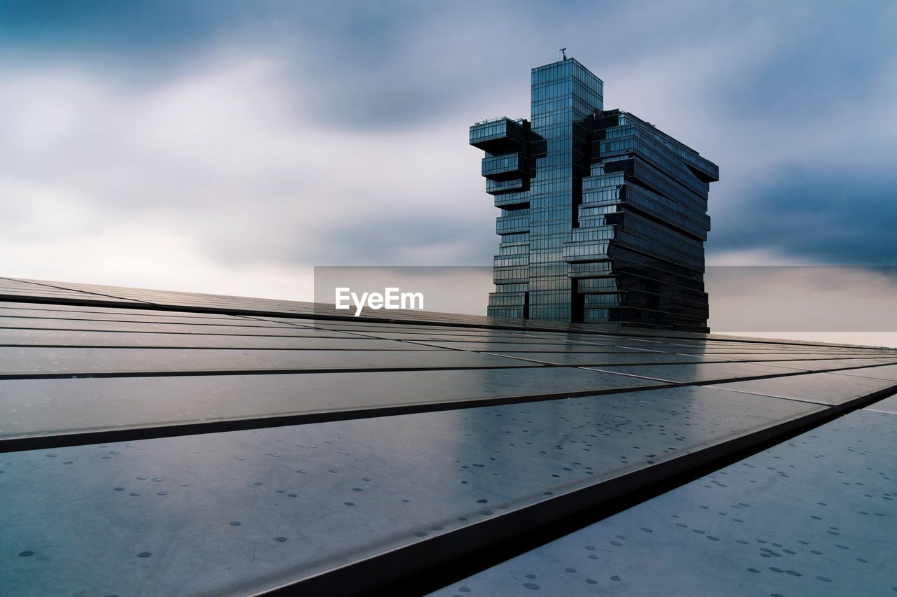 LOW ANGLE VIEW OF GLASS BUILDING AGAINST SKY