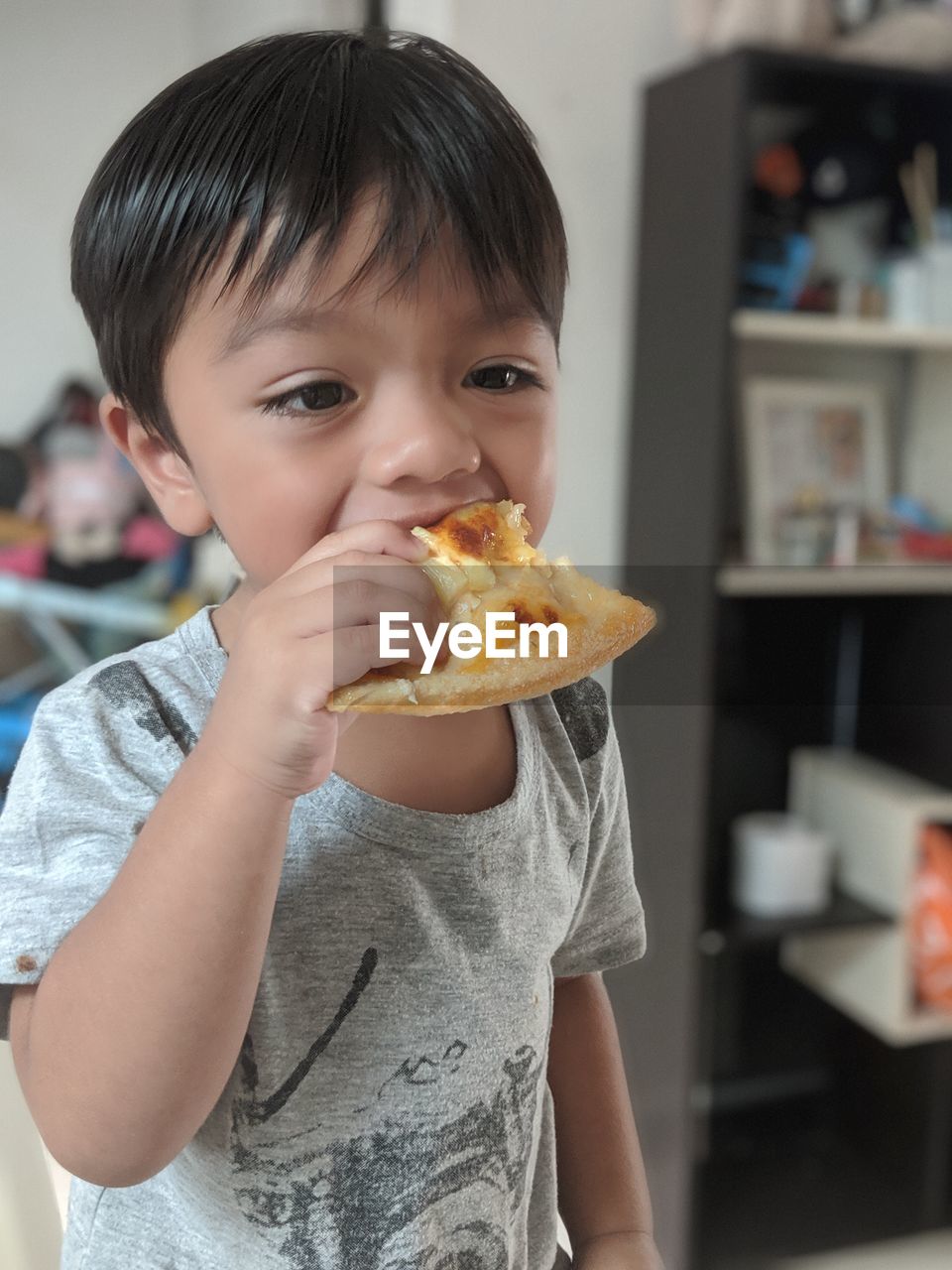 FULL LENGTH PORTRAIT OF BOY HOLDING ICE CREAM AT HOME