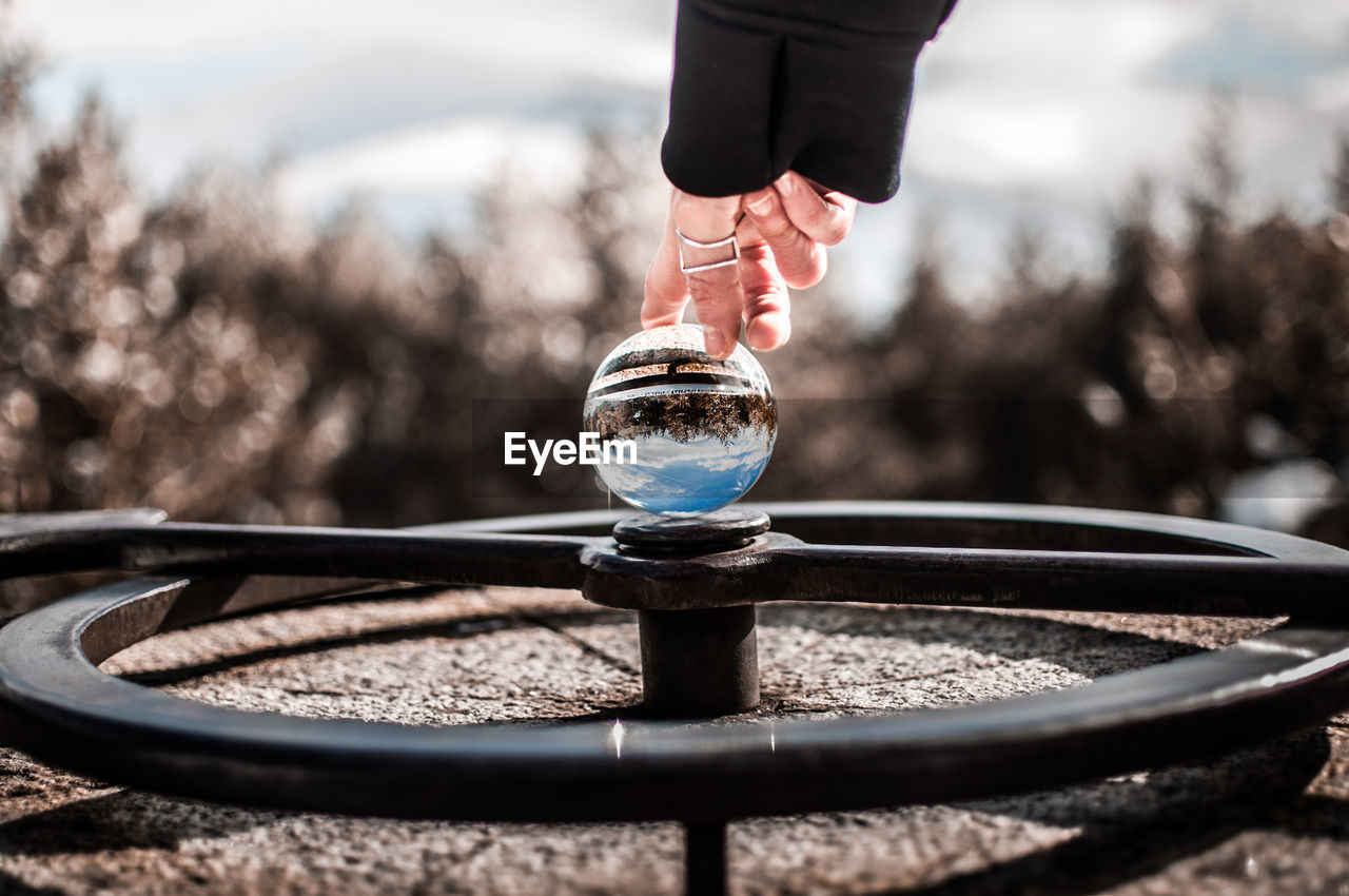 Cropped hand touching crystal ball on wheel