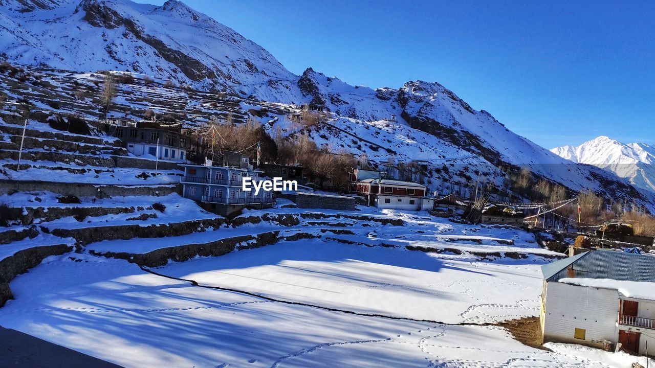 SNOW COVERED BUILDINGS AGAINST MOUNTAIN