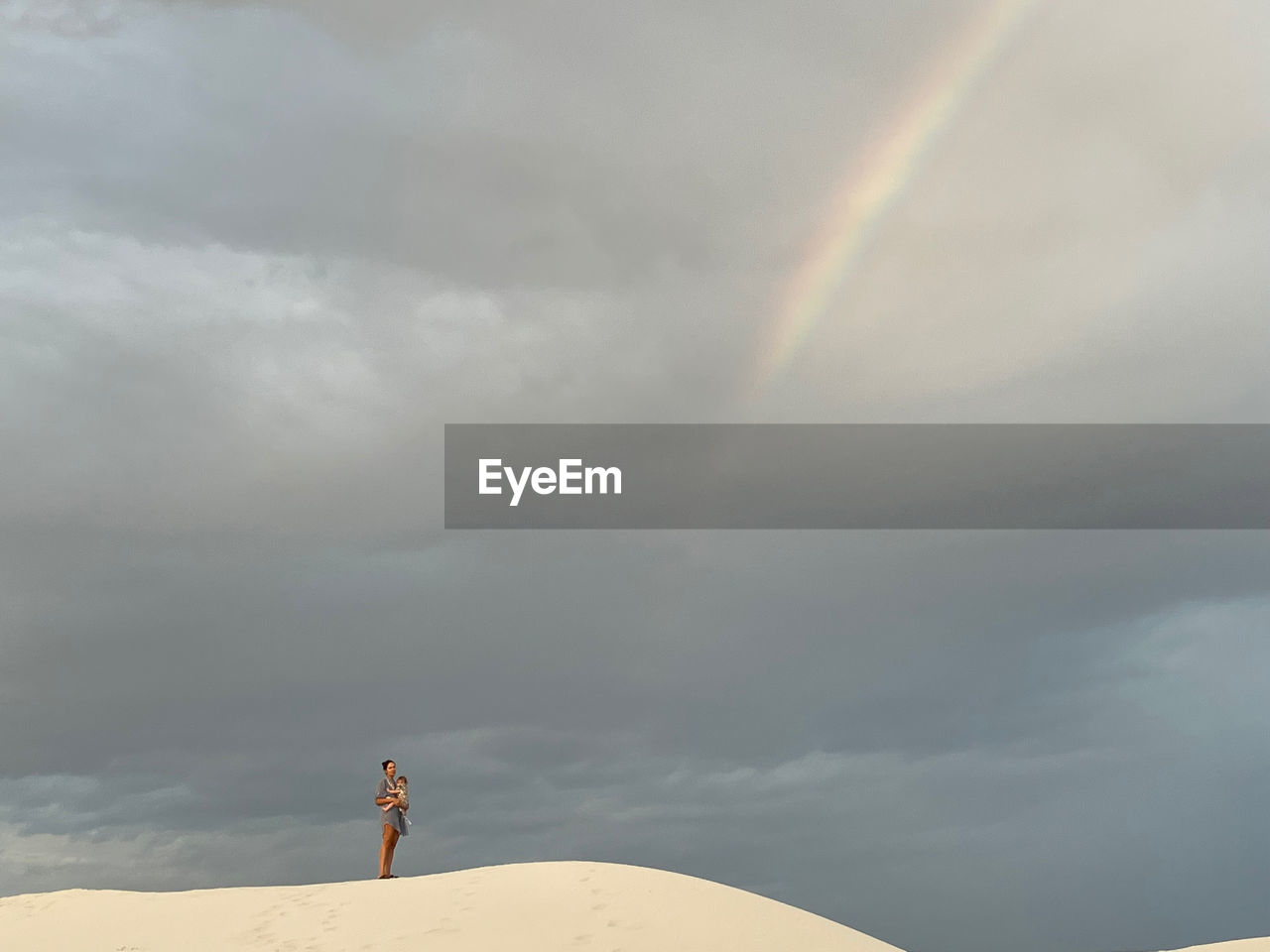 Rear view of man standing on mountain against sky