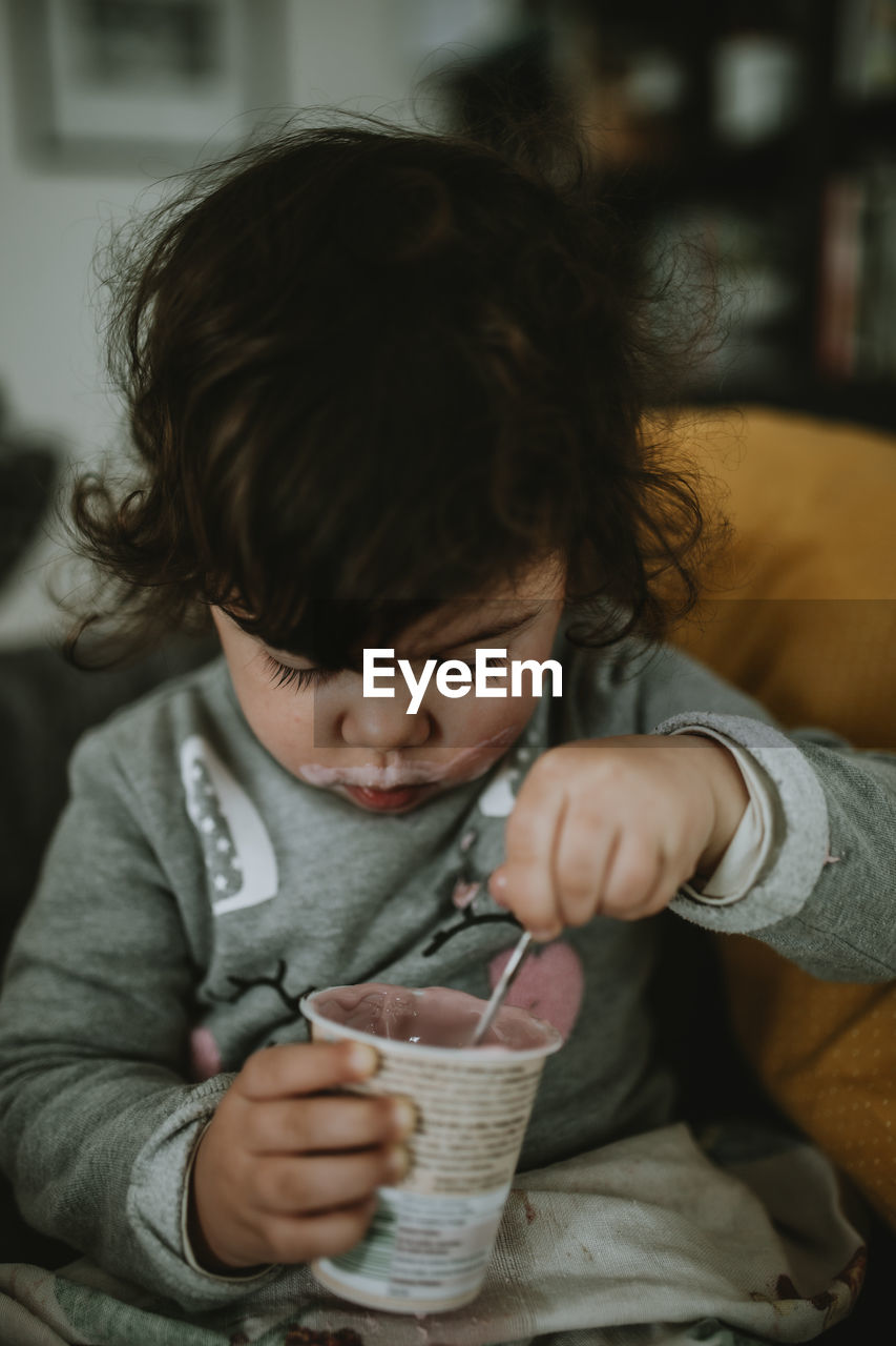 Midsection of a child eating yogurt