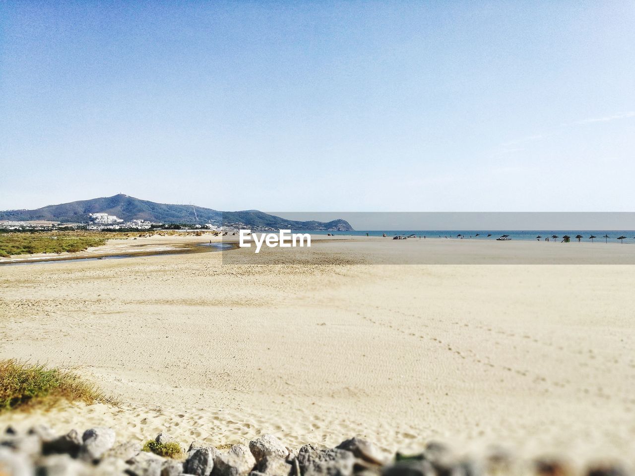 Scenic view of beach against clear blue sky