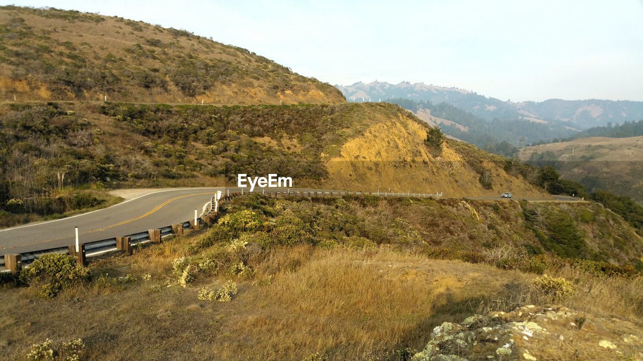 Scenic golden autumn view of road through mountains against sky