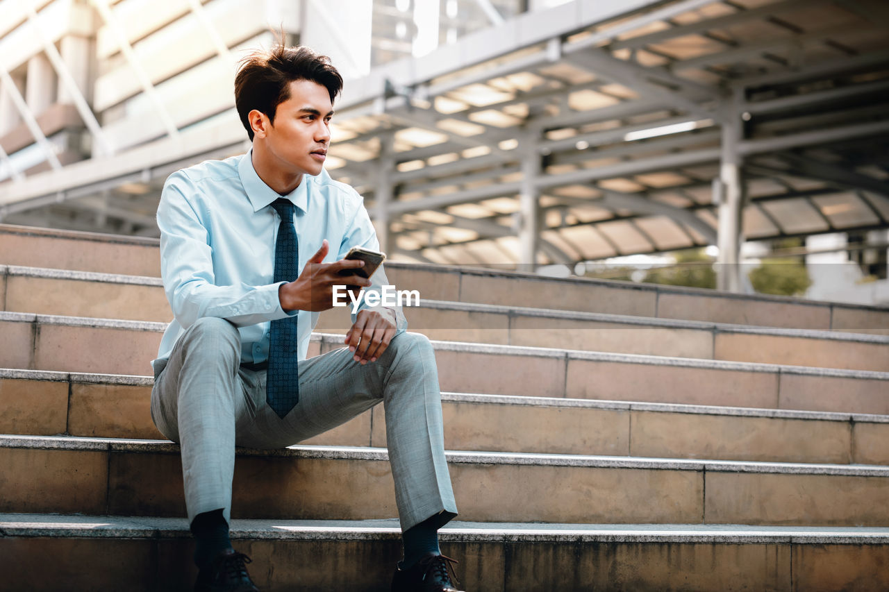 MAN SITTING ON STAIRCASE