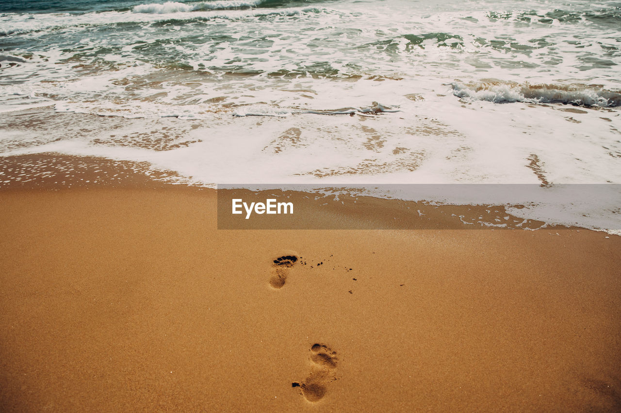 HIGH ANGLE VIEW OF FOOTPRINT ON BEACH