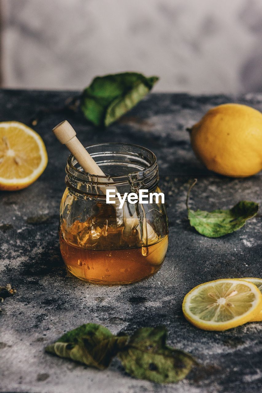 High angle view of fruits and honey in jar on table