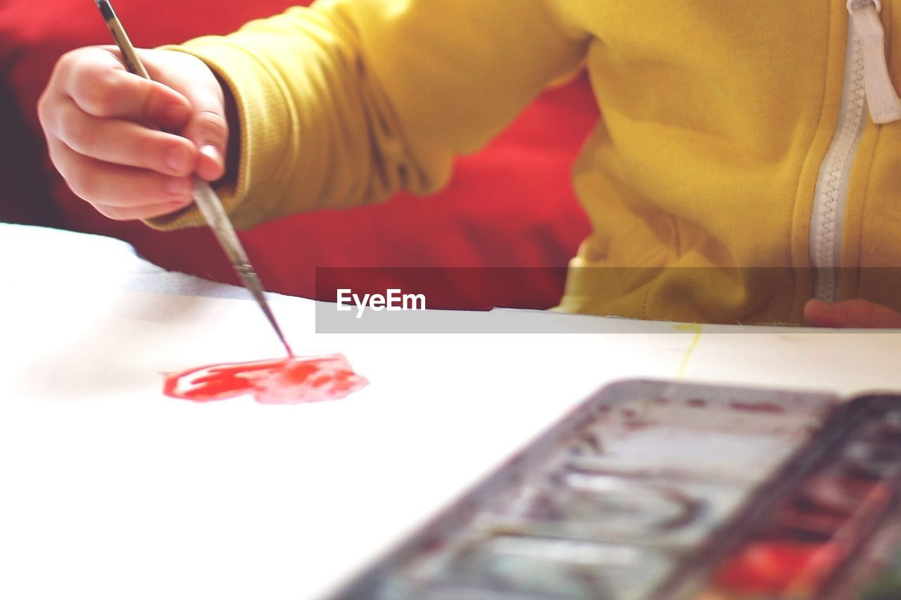 Close-up mid section of a kid painting heart