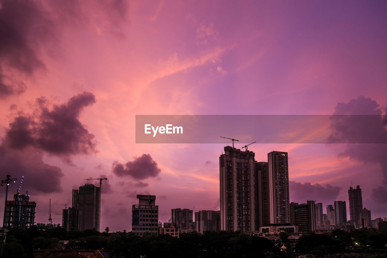 Silhouette buildings against sky during sunset