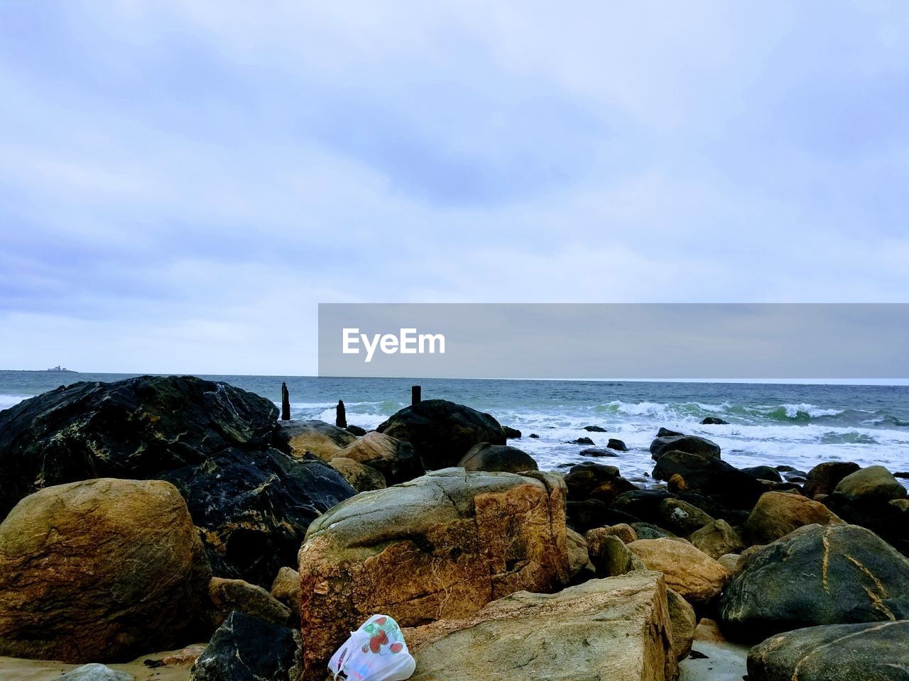 ROCKS ON SHORE AGAINST SKY