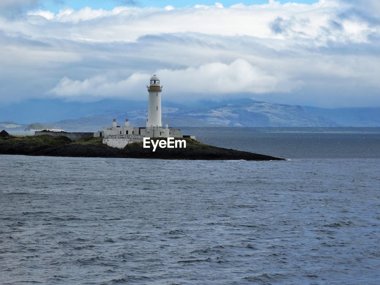 LIGHTHOUSE AT SEA AGAINST SKY