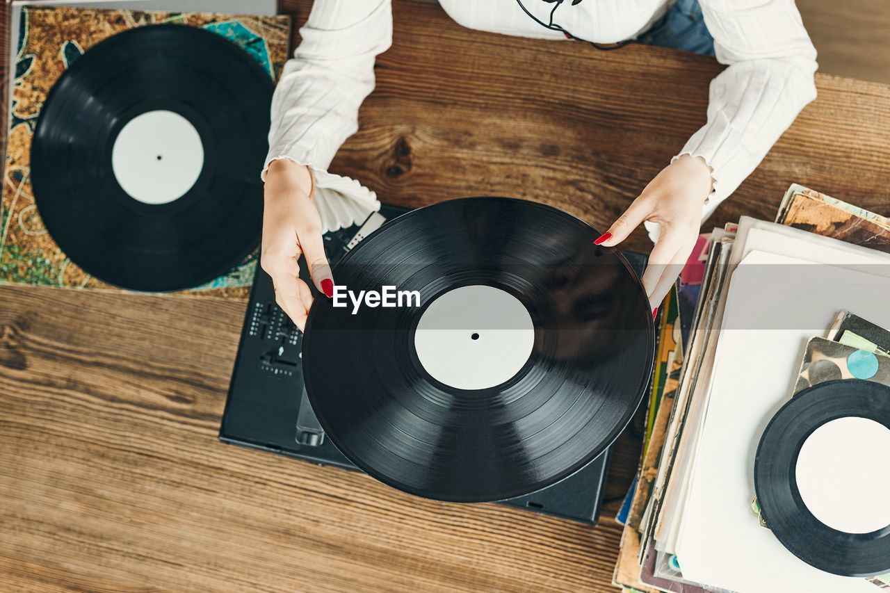 Woman playing music from vinyl record. analog record. retro and vintage style. analog sound. music