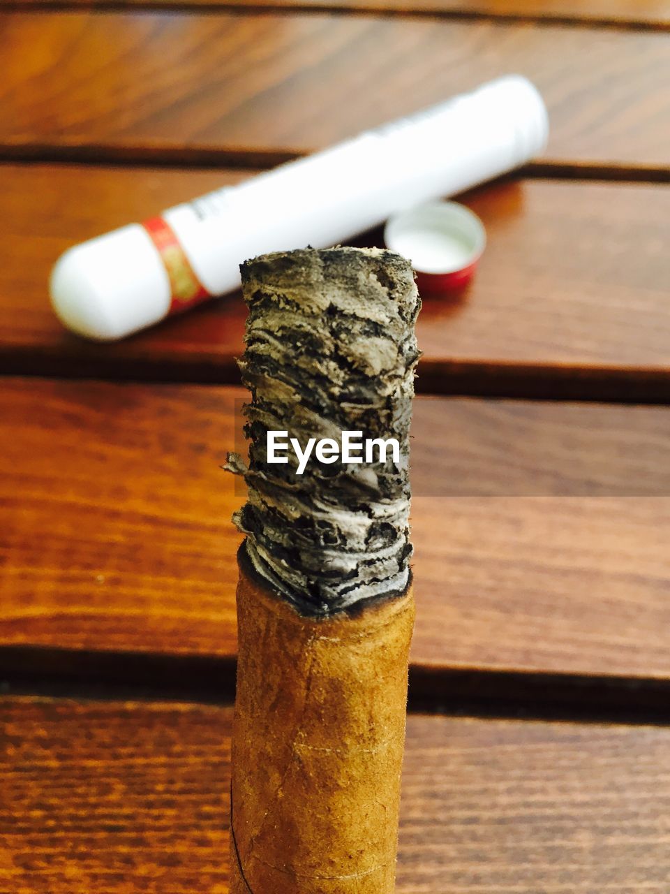 Close-up of burnt cigarette butt on wooden table